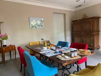a dining room with a table with colorful chairs at Ermitage Notre Dame de Vacquieres in Noves