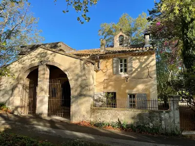 an old stone house with a gate in front at Ermitage Notre Dame de Vacquieres in Noves