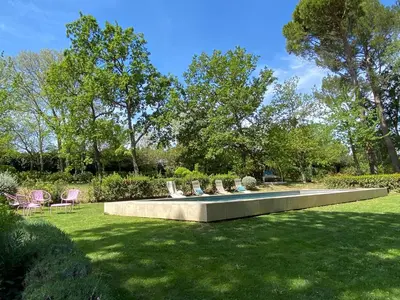 a garden with chairs and a pool in the grass at Ermitage Notre Dame de Vacquieres in Noves