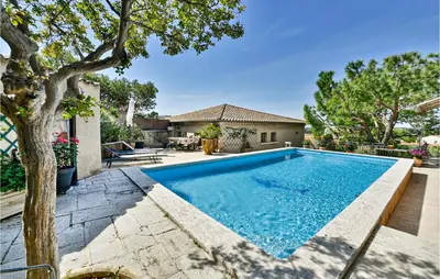 a swimming pool in the backyard of a house at 2 Bedroom Amazing Home In Châteaurenard in Châteaurenard