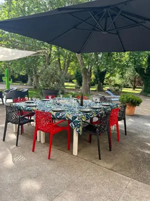 a group of tables with chairs and an umbrella at Bastide Sainte Marie in Mallemort
