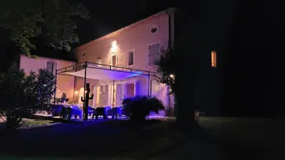 a house with purple lights on the side of it at night at Bastide Sainte Marie in Mallemort