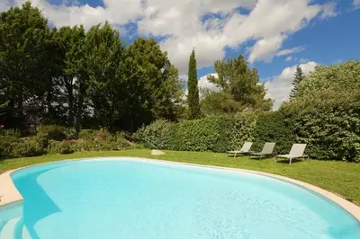a swimming pool in a yard with two chairs at Bastide Magnolia - Gite et chambres d 'hôtes Les dépendances, Roussillon in Roussillon