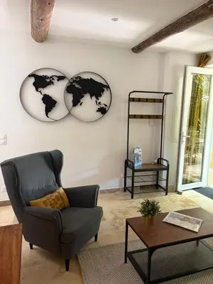 a living room with a couch and a globe on the wall at Le mas des glycines - parking privé et terrasse ombragée in Salon-de-Provence