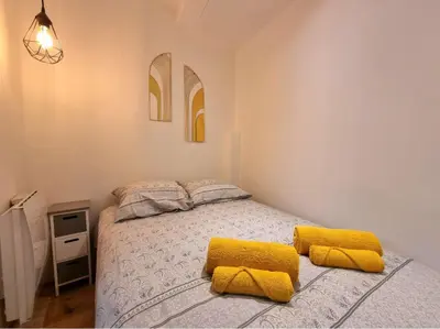 a bedroom with a bed with yellow pillows on it at T2 Centre Historique Rénové in Aix-en-Provence