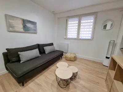 a living room with a black couch and a table at T2 Centre Historique Rénové in Aix-en-Provence