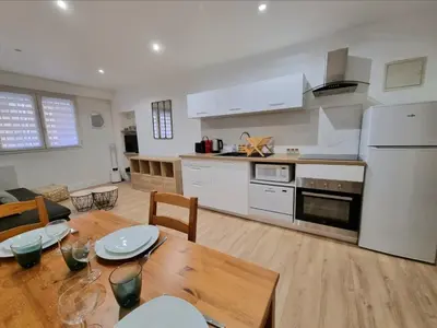 a kitchen and living room with a wooden table and a dining room at T2 Centre Historique Rénové in Aix-en-Provence