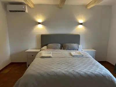a bed in a room with two lights on the wall at La Meynardière in Saint-Pierre-de-Vassols