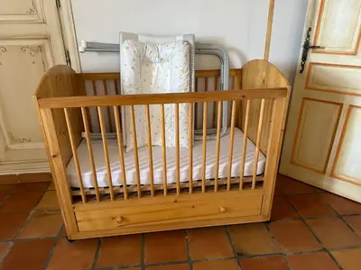 a wooden crib sitting on the floor in a room at La Meynardière in Saint-Pierre-de-Vassols