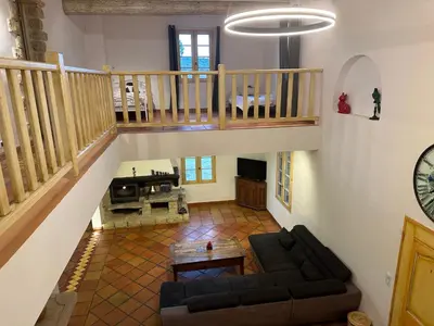 a living room with a couch and a staircase at La Meynardière in Saint-Pierre-de-Vassols