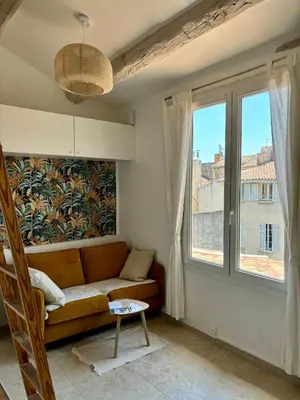 a living room with a couch and a window at Beau studio au cœur d’Aix et du Cours Mirabeau in Aix-en-Provence