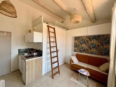 a living room with a ladder and a couch at Beau studio au cœur d’Aix et du Cours Mirabeau in Aix-en-Provence