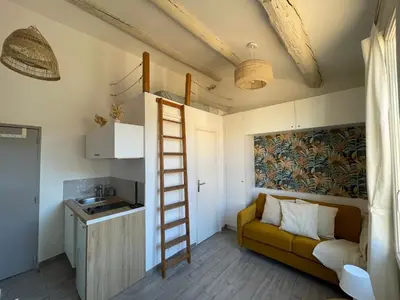 a living room with a ladder and a couch at Beau studio au cœur d’Aix et du Cours Mirabeau in Aix-en-Provence