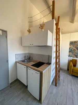 a small kitchen with white cabinets and a sink at Beau studio au cœur d’Aix et du Cours Mirabeau in Aix-en-Provence