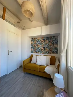 a living room with a couch and a painting on the wall at Beau studio au cœur d’Aix et du Cours Mirabeau in Aix-en-Provence