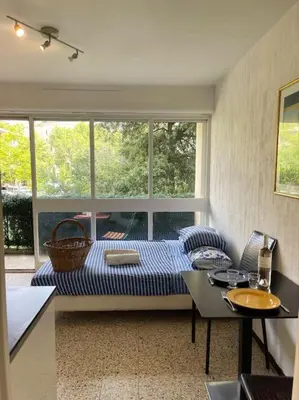 a room with a bed and a table and a window at Studio au cœur d'Aix avec balcon et parking in Aix-en-Provence