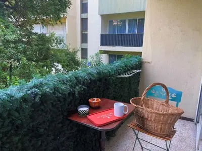 a table and chairs with a red tray and a basket at Studio au cœur d'Aix avec balcon et parking in Aix-en-Provence