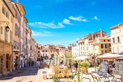 a city street with buildings and people walking down a street at Studio au cœur d'Aix avec balcon et parking in Aix-en-Provence