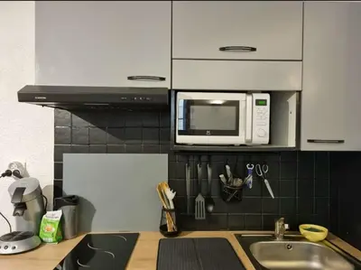 a kitchen with a sink and a microwave above a counter at Appartement centre historique in Aix-en-Provence