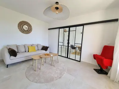 a living room with a couch and a table at Appartement spacieux de standing - parking gratuit in Aix-en-Provence