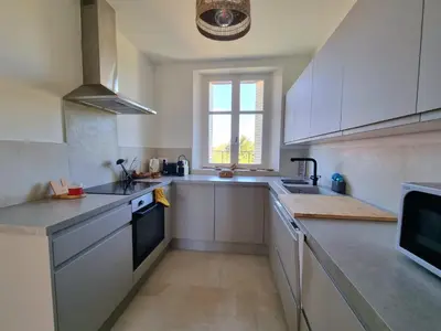 a large kitchen with white cabinets and a window at Appartement spacieux de standing - parking gratuit in Aix-en-Provence