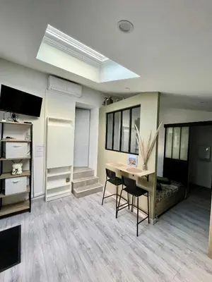 a room with a desk and a table and chairs at Studio climatisé et tout équipé in Saint-Didier