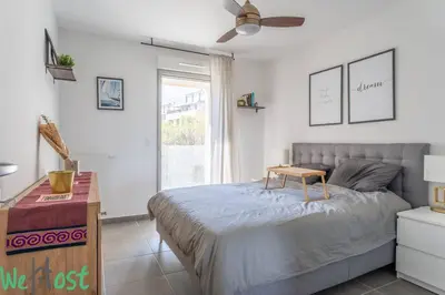 a bedroom with a bed with a table and a ceiling fan at Superb Apartment - Downtown Aix-en-Provence in Aix-en-Provence