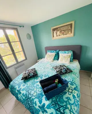 a bedroom with a bed with a blue and white comforter at Magnifique villa -piscine privée vue Mont Ventoux in Malemort-du-Comtat