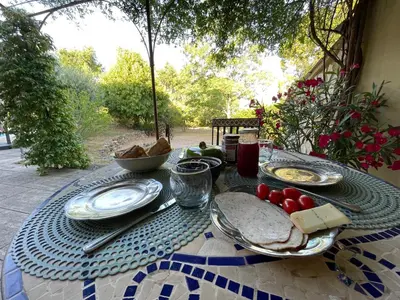 a table with plates of food on top of it at Magnifique villa -piscine privée vue Mont Ventoux in Malemort-du-Comtat
