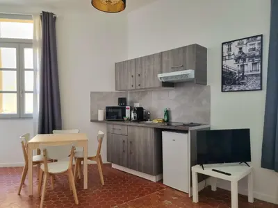a kitchen with a table and a tv and a dining room at Studio centre historique 1 in Aix-en-Provence
