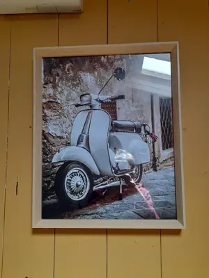 a picture of a scooter hanging on a wall at UN MOMENT SUSPENDU in Aix-en-Provence
