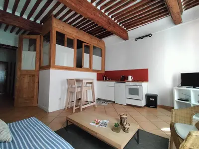 a living room with a bed and a table and a kitchen at CORDELIERS MAIRIE in Aix-en-Provence